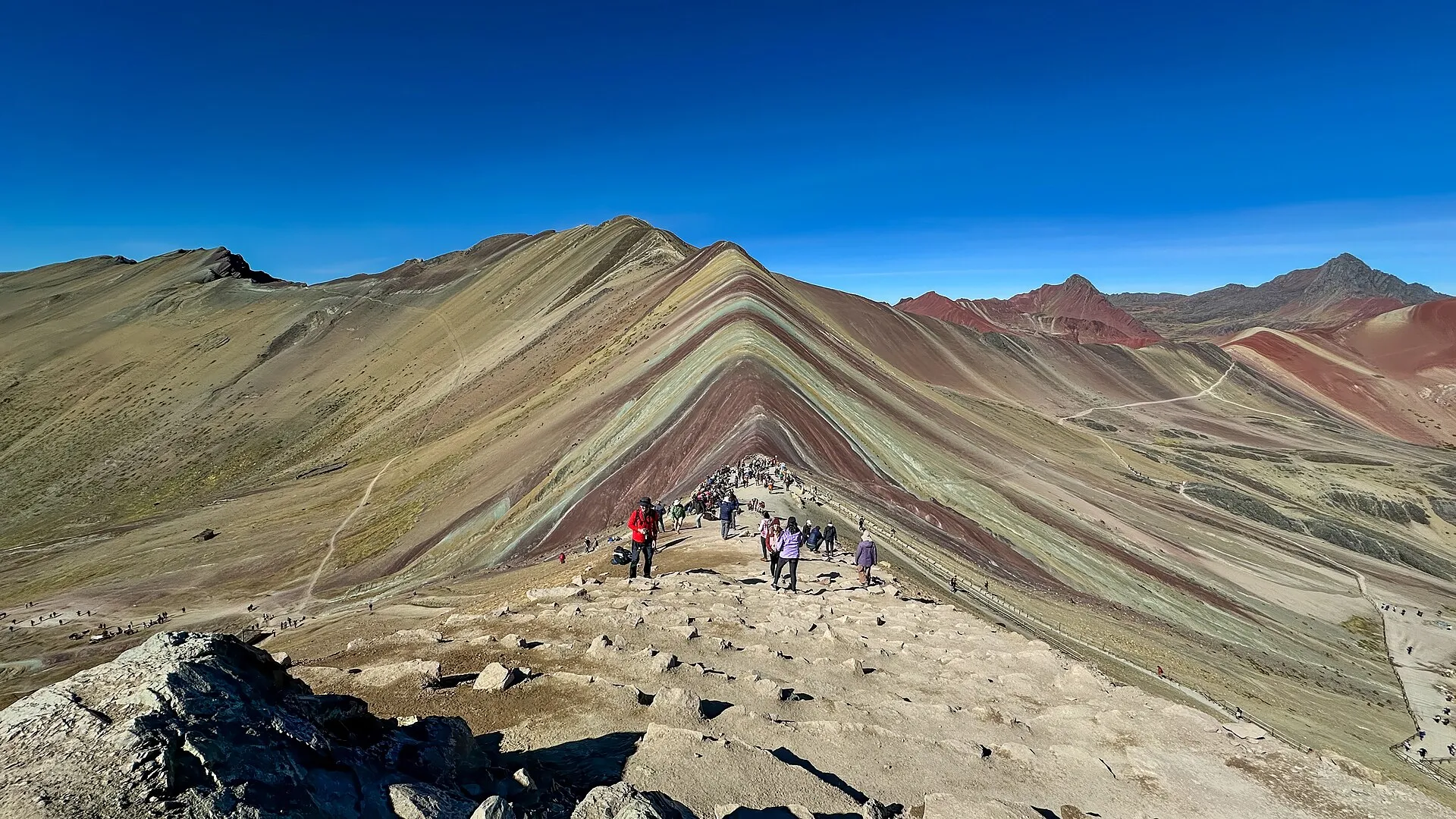 Franjas minerales de colores en la montaña Vinicunca bajo cielo despejado
